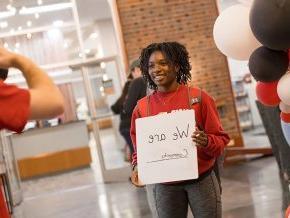 Student holds a sign reading 'We are community'